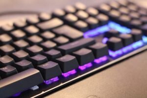 Angled view of a backlit mechanical keyboard glowing in the dark.