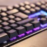 Angled view of a backlit mechanical keyboard glowing in the dark.