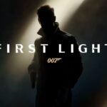 Dark image with a small beam of light revealing a silhouette of 007 alongside the “007 First Light” title and gold gun logo.