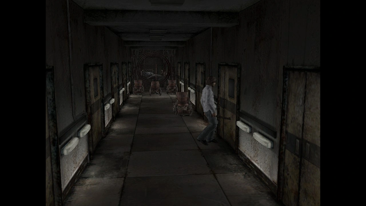 A rust-stained hospital corridor lined with empty wheelchairs.