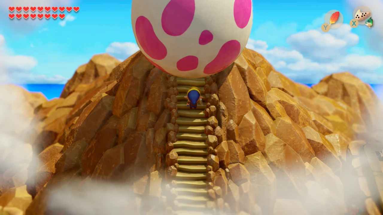 Link stands on the mountain steps below the Wind Fish’s Egg in The Legend of Zelda: Link’s Awakening (2019)