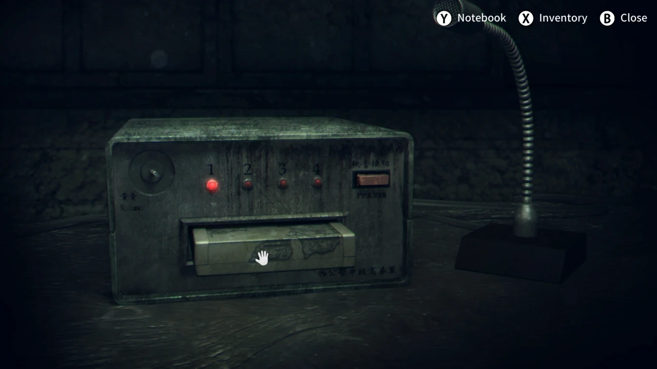 First-person puzzle view showing a cassette player with the hand cursor hovering over the tape