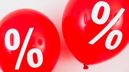 Red balloons featuring percentage symbols, ideal for sales and promotions. Black Friday 2025.