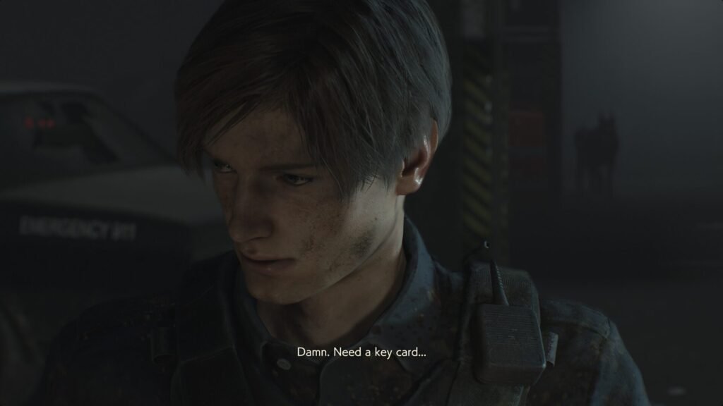 A close-up of Leon S. Kennedy in Resident Evil 2 Remake looking frustrated with the subtitle "Damn. Need a key card..." during a gameplay sequence.
