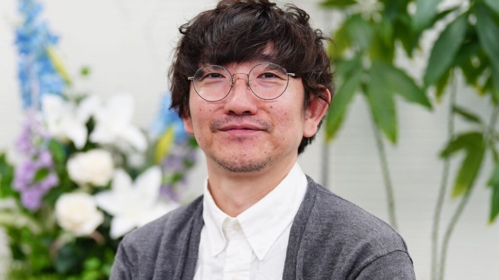 Shutaro Iida, Creative Director of ArtPlay and lead programmer for Castlevania, smiling while wearing a grey cardigan and glasses.