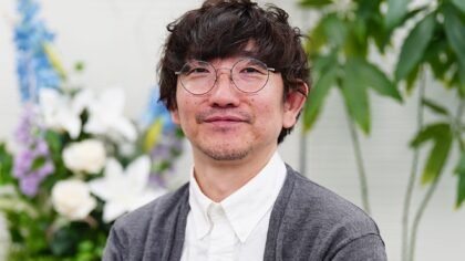 Shutaro Iida, Creative Director of ArtPlay and lead programmer for Castlevania, smiling while wearing a grey cardigan and glasses.
