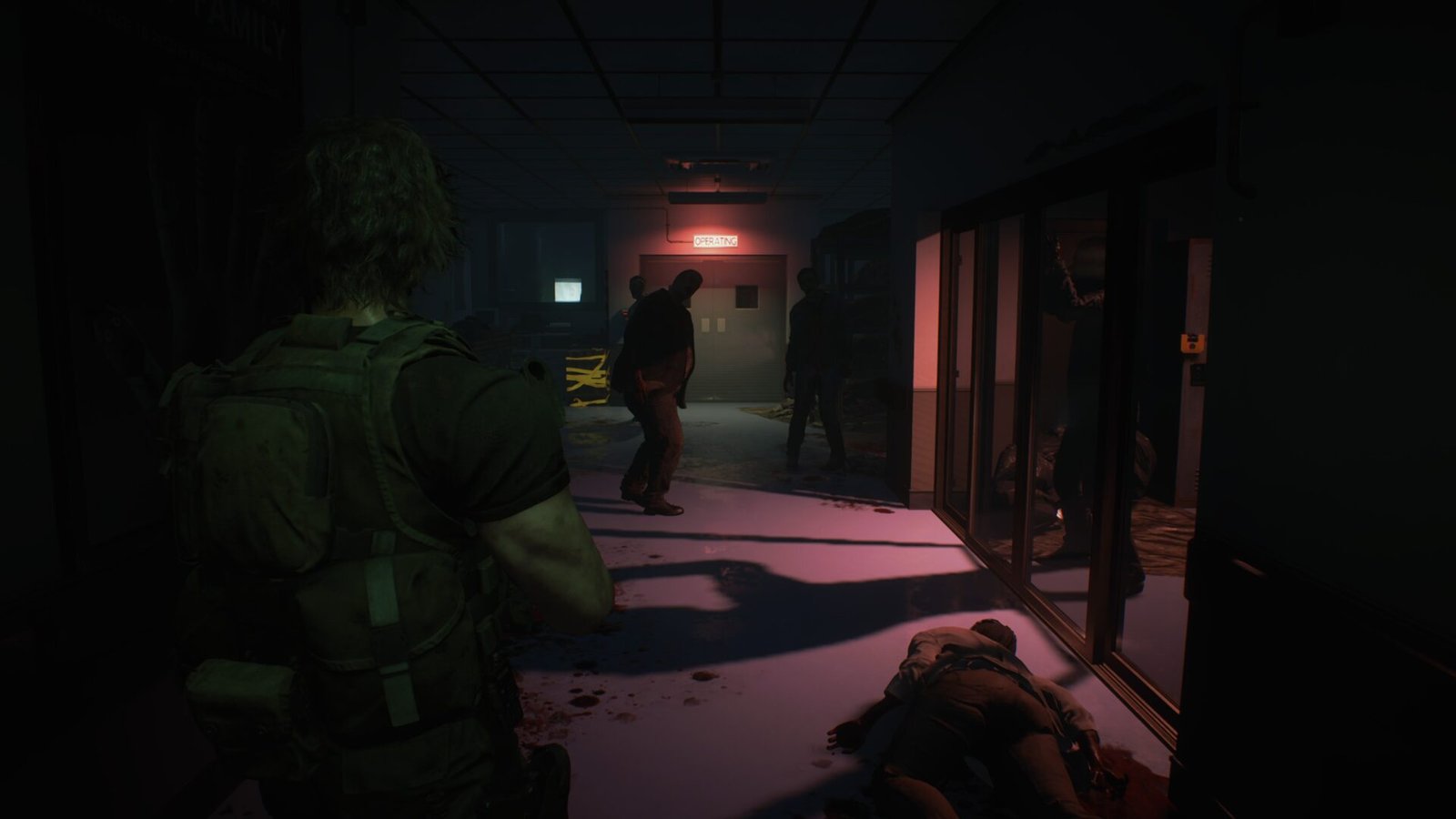 Carlos Oliveira in a dark hospital hallway illuminated by a glowing red "OPERATING" sign with zombies standing in the shadows.