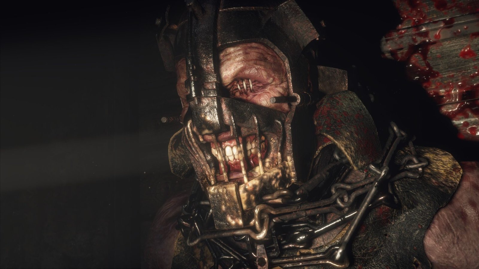 A close-up of the terrifying Garrador enemy wearing a metal helmet with sewn-shut eyes in Resident Evil 4 (2023).