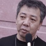 Yoshihisa Kishimoto, creator of the Double Dragon and Kunio-kun series, speaking into a microphone during an interview.