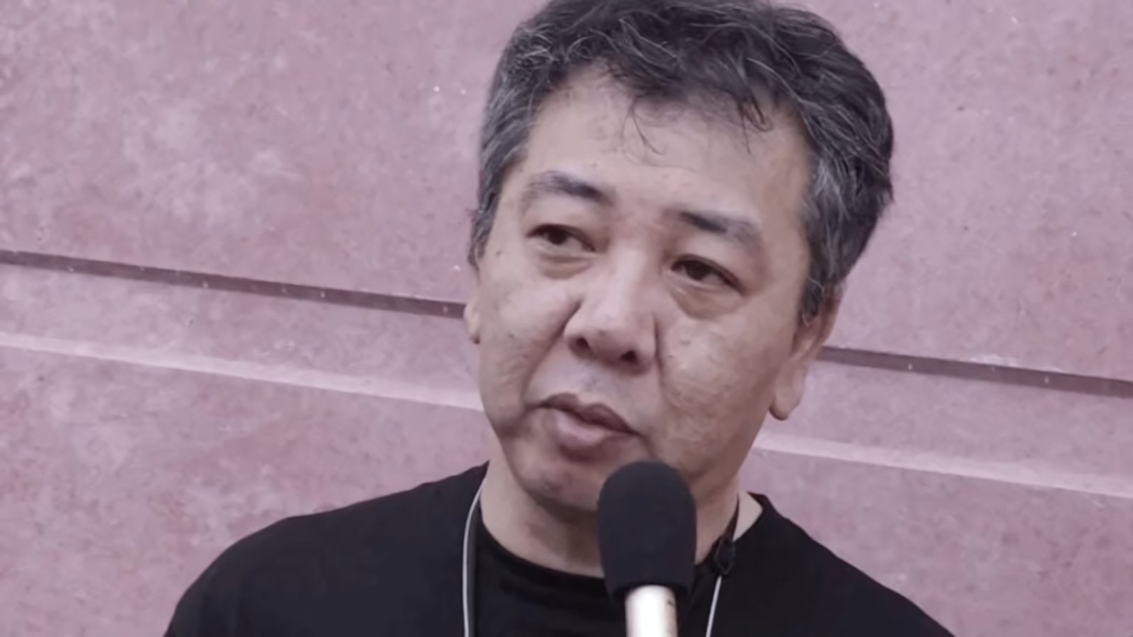 Yoshihisa Kishimoto, creator of the Double Dragon and Kunio-kun series, speaking into a microphone during an interview.
