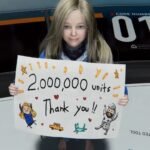 Diana from PRAGMATA holding a hand-drawn "Thank You" sign to celebrate the two million units milestone.