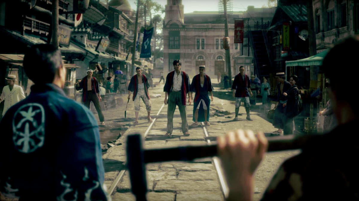 Makoto Daito stands with a group of workers on tram tracks in the 1915 Kokura era of STRANGER THAN HEAVEN Release Window.