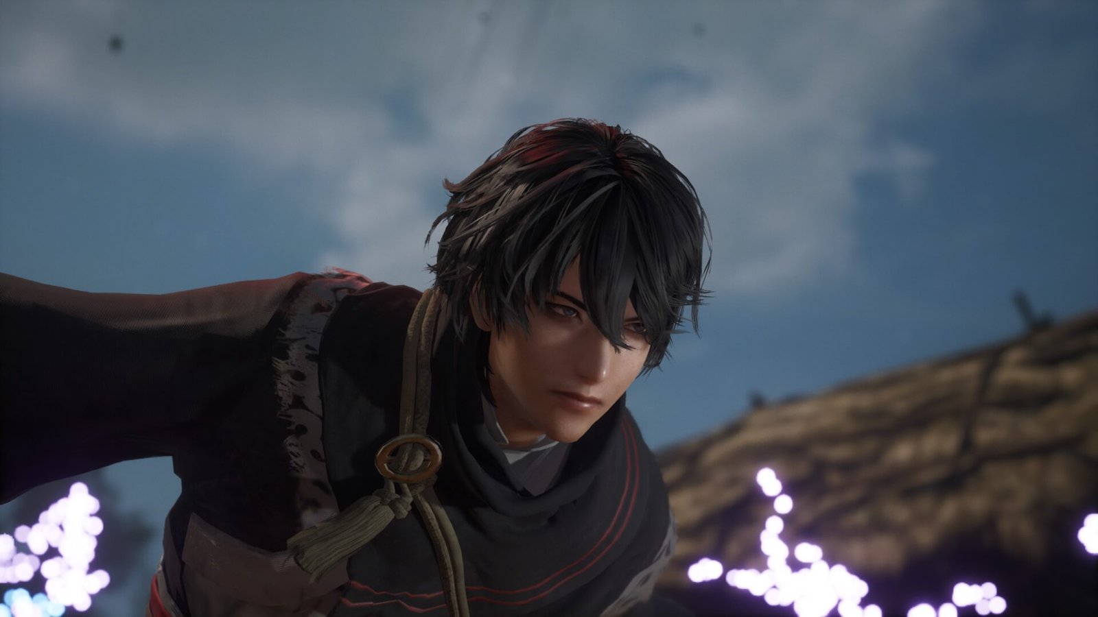 A close-up character portrait of the dark-haired Nameless Hero from Dynasty Warriors Origins looking intently off-camera under a cloudy sky.