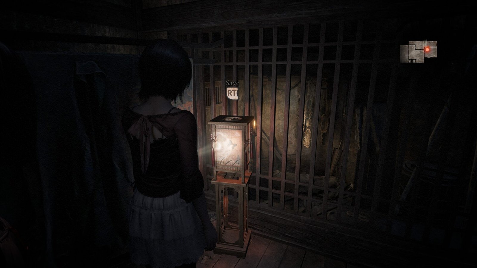 Mio standing in front of a glowing red save lantern inside a dark, wooden residential building.
